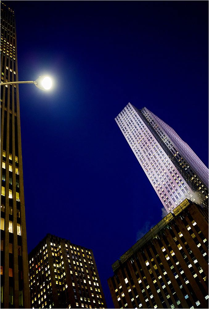 Architekturaufnahme. Stimmungsvoll hell erleuchtete Wolkenkratzer in NYC bei Nacht. Available Light Fotografie. Copyright by Fotostudio Jörg Riethausen 