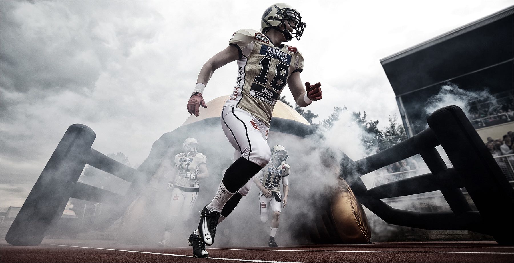  Reportagefotografie. Die Monarchs, das Football Team Dresden`s, während des Einlaufens ins Stadion in Dresden. Aufgenommen mit Weitwinkel und digital Kleinbildtechnik. Copyright by Fotostudio Jörg Riethausen 