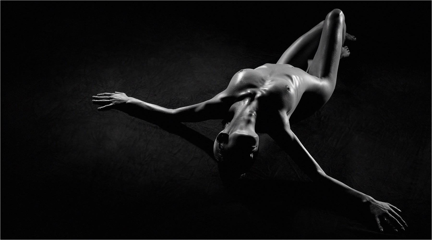  Liegendes Model als Halbaktaufnahme mit angewinkelten Beinen und Kopf zur Kamera. LowKey im Studio mit Kleinbild digital DSLR aufgenommen. Copyright by Fotostudio Jörg Riethausen 