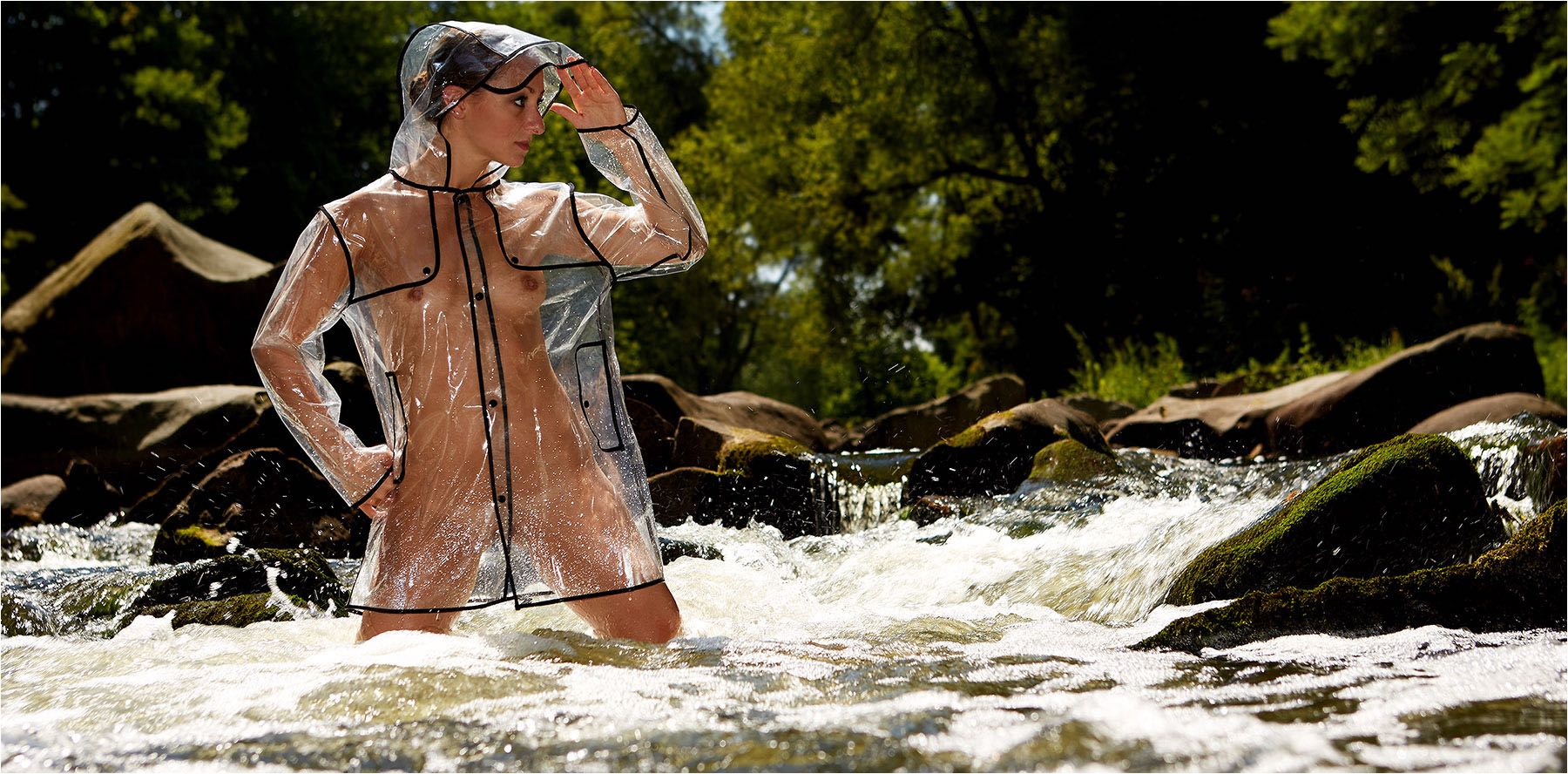  Verdeckter Akt mit transparentem Regenmantel in einem Gebirgsfluss stehend. Reportageblitzgerät und digital Klerinbildkamera. Copyright by Fotostudio Jörg Riethausen 