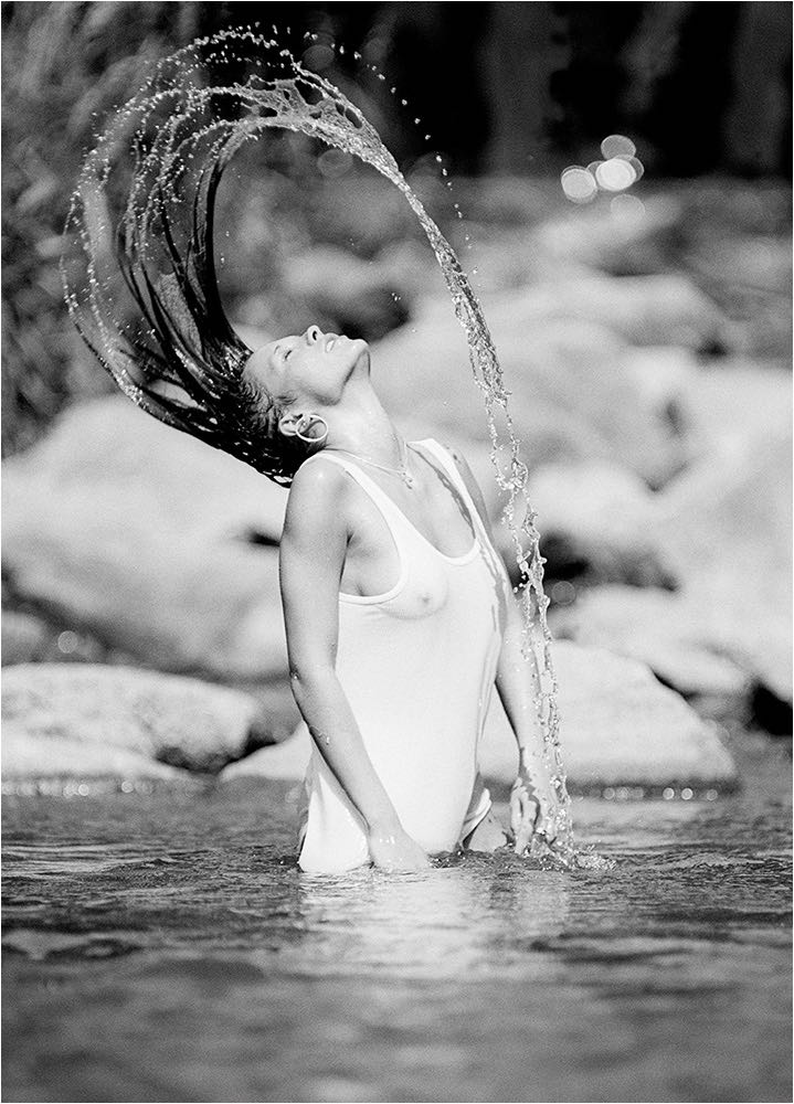  Schwungvolle verdeckte Aufnahme einer Frau mit nassen Haaren im Fluss stehend. Reportageblitz und analog Kleinbildkamera. Copyright by Fotostudio Jörg Riethausen 