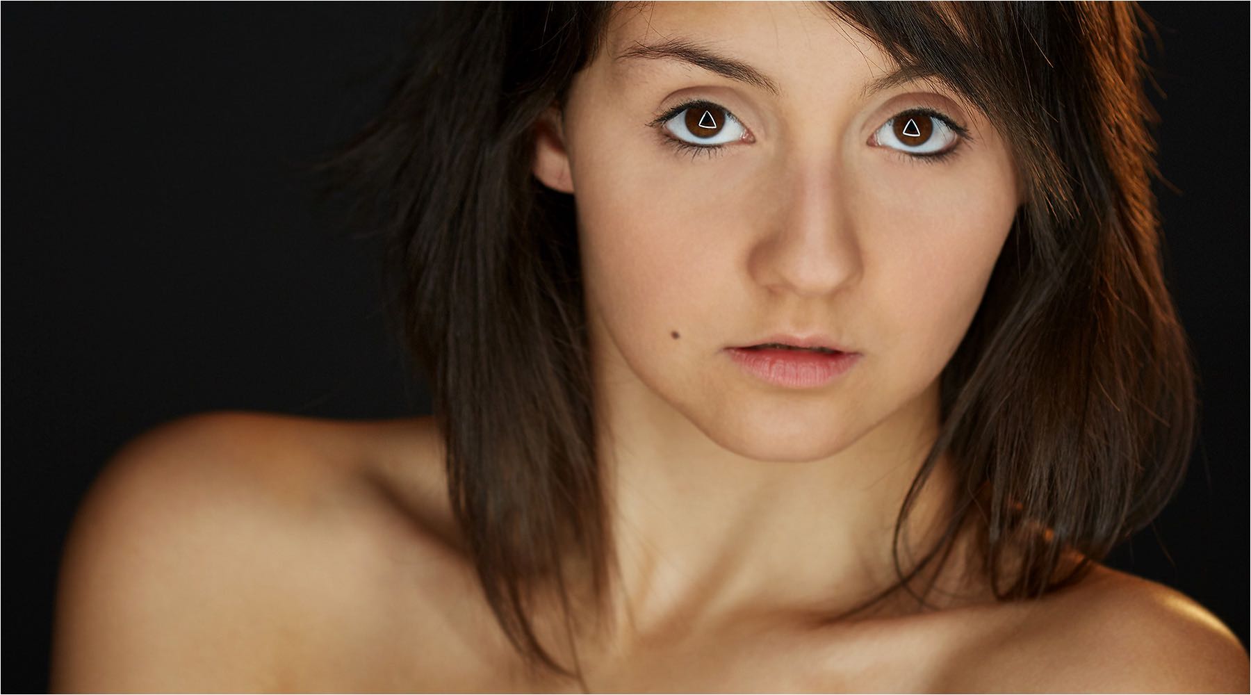  Porträt eines Models mit aussergewöhnlichem Dreiecks Reflex in den Augen. Aufgenommen im Studio mit vorhandenem Licht und Kleinbildkamera digital. Copyright by Fotostudio Jörg Riethausen 