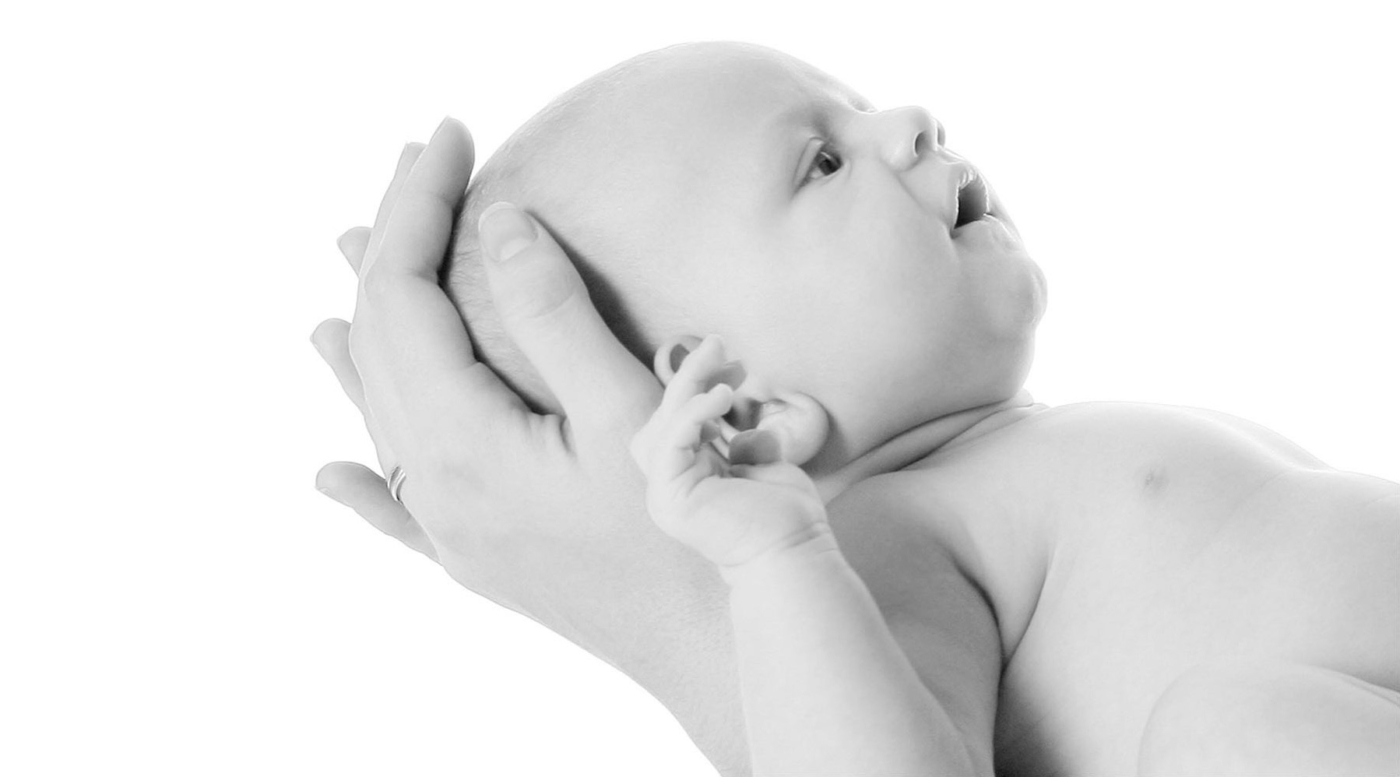 Hände einer glücklichen Mutter halten ihr Baby als Nah Portrait Aufnahme in Schwarz Weiss