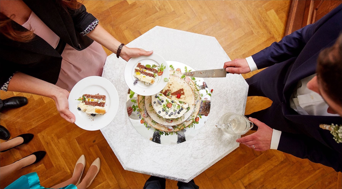Der Bräutigam schneidet die Hochzeitstorte an. Blick von oben