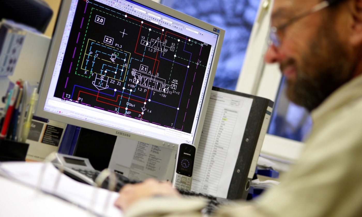 Konstrukteur an seinem Arbeitsplatz Technisches Schema auf dem Bildschirm