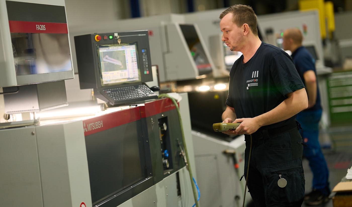 Maschinenbediener von Riwotec bei der Arbeit mit Steuerkonsole in der Hand