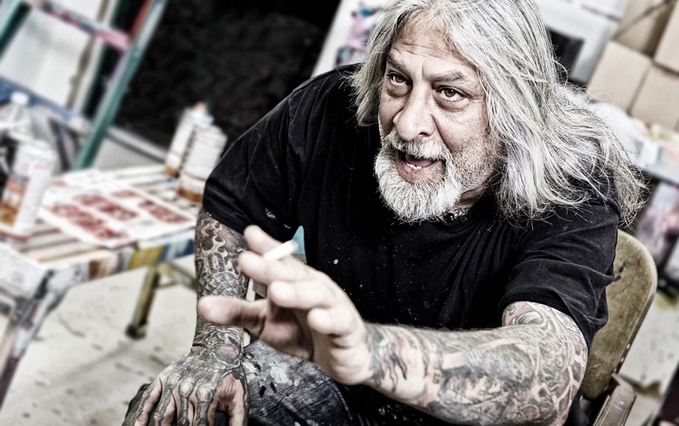 Graffitykünstler im hitzigen Gespräch mit Zigarette in der Hand in seinem Atelier